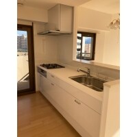 リビングと繋がる白基調の対面キッチン