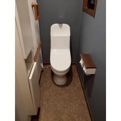 お掃除しやすいTOTOの一体型トイレを1日で設置。ダークグレーの内装と木目の温かみが調和する上質な空間に仕上げました。
