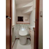 リーフ柄のアクセントクロスが印象的な明るい空間のトイレへ!