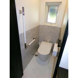 給水配管のやり替えやトイレ本体をタンクレスタイプにすることで以前よりも広々とスッキリしました。
腰高の壁と床にはホーロークリーントイレパネルを貼り、汚れやにおいが付きにくく、さらにお掃除のしやすい空間へと変わっています。
腰上に貼っているクロスもデザイン性の高い＃1000番クロスを採用し、パネルの色味や光沢感との相乗効果も相まって、トイレ室内が以前よりも数段高い意匠性を放っております。