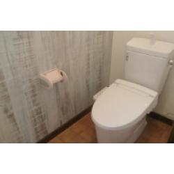 トイレの中を明るくしたい、見た目をかっこよくしたいとのご要望を頂きリフォームさせていただきました。 全体的に暗かったので壁を白くし、一面に明るい木目のアクセントクロスを使用しました。 床はテラコッタ調で落ち着いた雰囲気を。もちろん標準の節水型のトイレを設置させて頂きました。