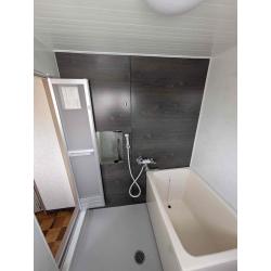 まるで新築のような明るく清潔感のある空間に生まれ変わりました！シャワー側の壁面は人気のダークブラウンの木目調パネルを採用し、落ち着きと高級感を演出。床は水はけが良く滑りにくい素材で、安全面も向上しています。シャワー水栓も新しくし、温度調整がしやすいサーモスタット式へ！さらに断熱性の高い浴槽で、お湯が冷めにくく光熱費の節約にもつながります。そしてこちらは元々、在来工法という職人が現場で一つひとつ作り上げていた浴室で既成のユニットバスだとサイズが無いため、床、天井、壁、浴槽それぞれをお客様にお好きなものを選んでいただき、職人が一つひとつ丁寧に施工させていただきました！