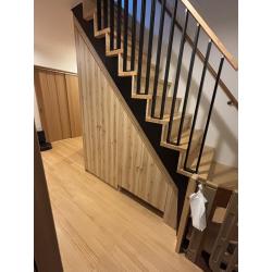 木造２F建の戸建住宅でスケルトン階段が設置されてましたが、お子様が怖くて登れないとの事で、階段の隙間を塞ぐと同時に階段下のスペースを収納に活用したいとの事で、ロボット掃除機、ステッィク型掃除機の収納スペースとちょっとしたアウター等が欠けれるような家具工事を行いました。既存の階段、壁、床等を傷つけないように直接ビス固定することなく、地震等の揺れで転倒しないように施工しております。