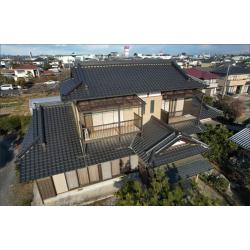 ドローンで撮影した施工後の全景です。築33年の重厚な和風建築の外壁が、無機ゼニスシリーズで塗り替えられました。劣化が進んでいたALC外壁全体に塗膜がしっかりと定着し、落ち着いたベージュ系の色で和の雰囲気を引き立てる仕上がりになっています。施工前に確認されたひび割れ目地はシーリング補修を行った上で塗装しており、見た目だけでなく防水性の回復もしっかりと図っています。瓦屋根の重厚な佇まいとのバランスも取れており、建物全体が引き締まった印象になりました。