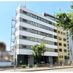 6階建てのビルの外観が長年の排気ガスなどの汚れもあり全面塗装されることとなり、ライトグレー基調でミドルグレーのボーダーにて塗り分けました。縦の2トーンのビルでしたが明るいボーダーの塗分けによって、すっきりワイドな印象になりました。１階のエントランス周りなどはガンメタリックのサイディングを張り、上階とのコントラストが高まり先進性も感じられるビルになりました。２階～5階が空いているため、内装も賃貸オフィス物件として改修しました(1階は駐車場、６階は入居中）。