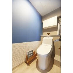 腰壁に調湿効果を期待できるエコカラットを採用したトイレ。部分的にブルーのクロスを貼り、アクセントをプラス。