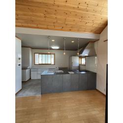 築20年の戸建てにお住まいのお客様。IHの故障やワークトップのひび割れがきっかけとなり、キッチンリフォームをご決断されました。お子様の独立を機に、これから先も快適に使えるキッチン空間をご希望でした。
採用いただいたのは、トクラス「コラージア」。メタリックスタッコの扉にメテオダークグレーのカウンターを組み合わせ、ブラックのライン取っ手を採用することで、スタイリッシュでモダンな印象に。床には落ち着いたグレーのフロアタイルを、天井にはグレーのアクセントクロスを取り入れ、空間全体を統一感のあるモダンデザインにコーディネート。キッチンだけでなく、空間全体が上質で洗練された雰囲気に生まれ変わりました。