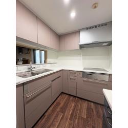 築26年を迎えたマンションにお住まいのご家族。レンジフードの交換をきっかけに、キッチン全体のリフォームをご決断されました。
ガスからIHへの変更や、カウンターの色・高さなど細かなご要望にも丁寧にご提案させていただきました。L型レイアウトはそのままに、コーナーに置いていた据置食洗機をビルトインへ変更し、収納スペースも広がり使い勝手が大きく向上しました。
トクラス コラージア リュッケファーブ ピンクのやわらかな色味を、濃いめのクッションフロアで引き締め、おしゃれで居心地のよいキッチン空間に。床や内装も合わせてリフォームし、空間全体が生まれ変わりました。
