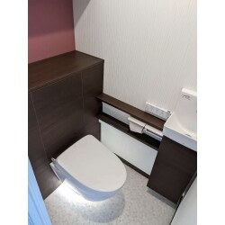 トイレキャビネットの色は落ち着いたブラウンをご選定されたので雰囲気のあるクロスを提案。
ラメ入りのワインレッド色のアクセントクロスを選びました。
キャビネット色の「ダルブラウン」と調和する素敵なトイレ空間になりました。