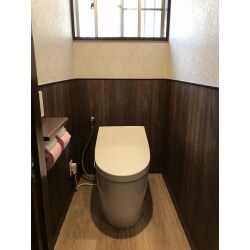 タンク付のトイレからタンクレスのトイレへ交換しました。内装は腰部分で張り分けし、汚れやすい腰下は濃いめの木目調のクロスを、腰上は高級感のあるフローラル柄のクロスを貼りました。タンクレストイレを選定することによって以前より前方の空間が広がりました。