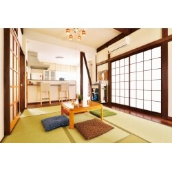 　中古物件探しでは、建築士の現地調査も同時に行って進めました。状態の良かった現在の住まいと出会い、柱や梁の状態をしっかりと見ながら、構造に負荷がかからぬように間取り変更を模索。住み替えにかかる総費用を考えながら、リフォームプランを練っていきました。　
　お客様の譲れないこだわりは、広々とした空間をつくること。二部屋に分かれていた1階は、仕切り戸と押入れを撤去し、室内壁も筋交いとすることで視線が抜ける広々LDKを実現しています。天井は梁が見える高さまで上げ、さらに、床座のスタイルのために、より広々と感じられるようになりました。優しい日差しが注ぐ、開放的なリビングを実現しました。
