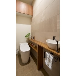 トイレの壁面はエコカラットでデザインと機能性をＵＰ。カウンター下にはお掃除道具を隠せるように収納しています。
