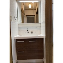 洗面台の収納は勿論、以前の洗面台は脇に隙間があり、ものが落ちてお困りでした。
また常時水はねがある洗面廻りの壁のお手入れのしにくさやカビの発生もご心配されていました。
弊社の営業職がお手入れしやすいキッチンパネルをご提案。パネルの厚みでシーリングで隙間がなくなり物が落ちるストレスも壁内部のカビのご心配も収納のお悩みもなくなり、
大変お喜びいただけました！