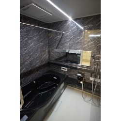 ブラックの浴槽と大理石調壁パネル
天井のフラットラインLED照明が高級感のある浴室を演出。