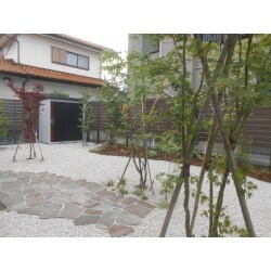 駐車場後方のお庭に何もないから…とお庭のプランを依頼してくださったＵ様。
玄関に立った時にリッラクスできるように、木目調の目隠しと雑木林風の植栽をご提案しました。一部を除き、足元は防草シートと砂利で雑草対策、見た目もスッキリと明るくなりました。