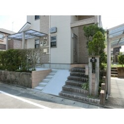 道路からお庭に自転車を上げられるよう、スロープを施工しています。ただ、道路とお庭とに高低差がありスロープの勾配が少し急になってしまうため、階段を両側につけさせていただいております。また、雨の日でも安心して自転車を停められるよう、サイクルポートをつけさせていただいております。