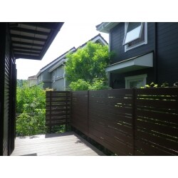目隠しとして、木調の模様がはいっている樹脂フェンスを使用しました。板の幅に変化をつけて隣地の植栽が良い感じに見え隠れしています。室内から見ると今まで以上に広く感じられるようになりました。