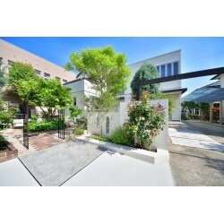 植物が大好きだけどお手入れを楽にしたいというご要望のもと、レンガや自然石でお庭のアプローチや花壇を作り、既存の植物をできるだけ残しながら雑草対策をしました。駐車場の端から門塀の裏につながるアーチをつけ、家の門構えを強調しています。アンティークレンガの色ムラが既存の植物と馴染み、明るく緑の映えるお庭になりました。
