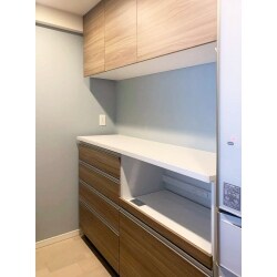 カップボード新設をご希望でした。ブルーグレーのクロスとブラウンの木製カップボードのコントラストが美しいキッチンへと生まれ変わりました。