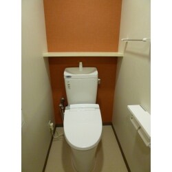 オレンジのアクセントクロスであたたかみのあるトイレ