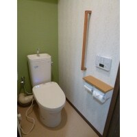 壁紙のグリーンがさわやかなトイレ
