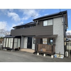 お客様よりメンテナンス性があり、濃い色合いの外壁材をご依頼頂きました。弊社からは既存外壁に凍害がみられた為、凍害を起こさず裏張り断熱された金属系のサイディングを使用。横方向の色分けから縦方向の色分けにし、お客様のご要望通り濃い色を使用することで完成後印象がガラッと変わる外観イメージを外観パース作成のもとご提案しました。