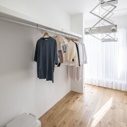 廊下に儲けた電動式の物干し掛け。乾いた衣類をそのまま隣のパイプに掛けることが出来る工夫がされています。