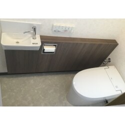 トイレ空間のリフォームをさせていただきました。コンパクトな手洗器付タンクレストイレを採用し、床・壁・天井を張替え。お掃除がラクな明るいトイレ空間になりました。