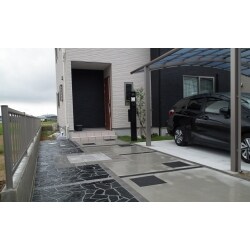建物の色に合わせたモノトーンのモダンな玄関アプローチになりました。 天然素材のオークルストーン乱形を使用し、 様々な形の石を組み合わせるので、動きが感じられるように。 モノトーンでも暗くならない様に、ピンコロ石でアクセントを付けました。 使用商品【東洋工業：オークルストーン乱形：アースブラック（石英岩）】