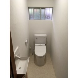 トイレの壁の一部を撤去し、広々としたトイレにリフォームしました。タイルの床・壁と土壁は白のクロスとクッションフロアに貼替えて清潔感ある空間に大変身しました。トイレ機器は超節水タイプで経済的です。　使用商品【トイレ：TOTO　ピュアレストEX】