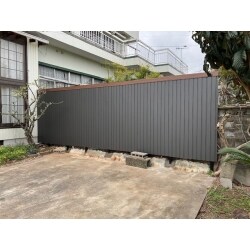 ガルバニウムの板金でメンテナンスを容易にし、ワンポイントで上部に木目調のアルミ材でアクセントにしました。