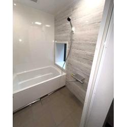 浴室は、天然石のような風合いを持つ磁器タイル床「キープクリーンフロア」が高級感を演出し、汚れに強く足元もあたたかい快適な空間です。
洗面にはTA社のリジャストを設置し、間口1cm刻みの仕上げに対応することで、壁とのすき間なくぴったりと納まり、限られたスペースでも無駄のない美しい仕上がりを実現しました。

