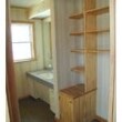 人工大理石カウンター，洗髪シャワー水栓付大型鏡の洗面所。収納棚を組み込んだ洗濯スペース
