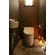 トイレの床も浴室と同じ諏訪鉄平石張り、壁は空間に合わせた色調の壁紙で仕上げました。