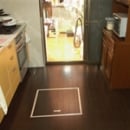 ダークブラウンの床に明るい色のキッチンパネルがコントラストを生みメリハリのある空間に。