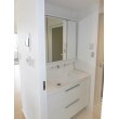 キッチンや浴室と同様に、洗面化粧台も清潔感ある白で統一。三面鏡、引き出しで収納も確保。