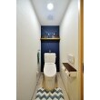 スペースを広げられないトイレを広く見せるため、四方を白に、後退色の濃い青を正面に配して奥行きを演出。