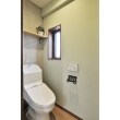 本物のタイルとアンティークなペーパーホルダーで高級感を出した玄関横のトイレ