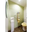 淡いグリーンのクロスをあしらった、清潔感のあるトイレです。長方形のミラーがオシャレな空間を演出し、明るくポップなトイレに生まれ変わりました。