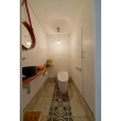 トイレ空間にもスペインのテイストを盛り込み、しっくいの壁に、スペインのタイルを床に貼りリゾート感を演出