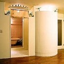 玄関からの動線をカーブさせるため、半径800㎜のシリンダー（円柱）を設置。また洋室からトイレに直接入ることを避けるべく、ワンクッションとなる全室をつくりました。普段はオープンにし、浴室利用時にのみ、すだれ調のローマンシェードで閉じるようにしています。