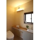 間接照明と柔らかい色合いの壁紙が、暖かい雰囲気のトイレを演出します。