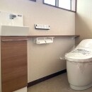 タンクレス風トイレでゆったりとした空間に。手のひらやひじで立ち座りのバランスを支えられる身体に優しいカウンター付き手洗いキャビネットも設置されました。