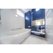 青色のアクセントパネルが印象的な浴室です。
横長の鏡を採用したことで、空間内を広く見せることができます。