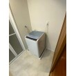 洗面室は洗濯機の下に敷いている防水パンのサイズを小さくし、隣接する収納棚のスペースを広げました。また、床・クロスの張替え工事を行いました。