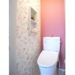 【施工後】２階トイレはピンクを基調とした空間に。トイレは使いやすい手洗い付きタイプ。雰囲気に合わせるため棚の塗装もしました。
