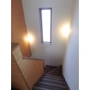 天井吊りの照明を壁付け２ヶ所に移設し、明るさと広がりを感じる階段になりました。