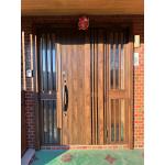 玄関扉はアルミから木目調に、重厚感のある佇まい。