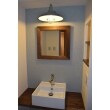 ダークブラウンの木目とアンティークブルーの壁紙で雰囲気のある洗面スペースに。