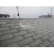 屋根の高圧洗浄の様子です。水に圧力をかけて（150kgf/cm2以上）長年の汚れやコケを落としていきます。軒先にコケが生えやすく、しっかり除去後に塗装していきます。
